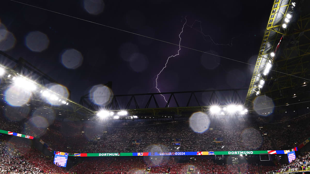 "البرق" يظهر في سماء ملعب مباراة ألمانيا والدنمارك.. ومشجعان يرقصان تحت مياه الأمطار